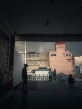 Silhouette of people in a Mexican urban setting with Torre Latinoamericana in view.