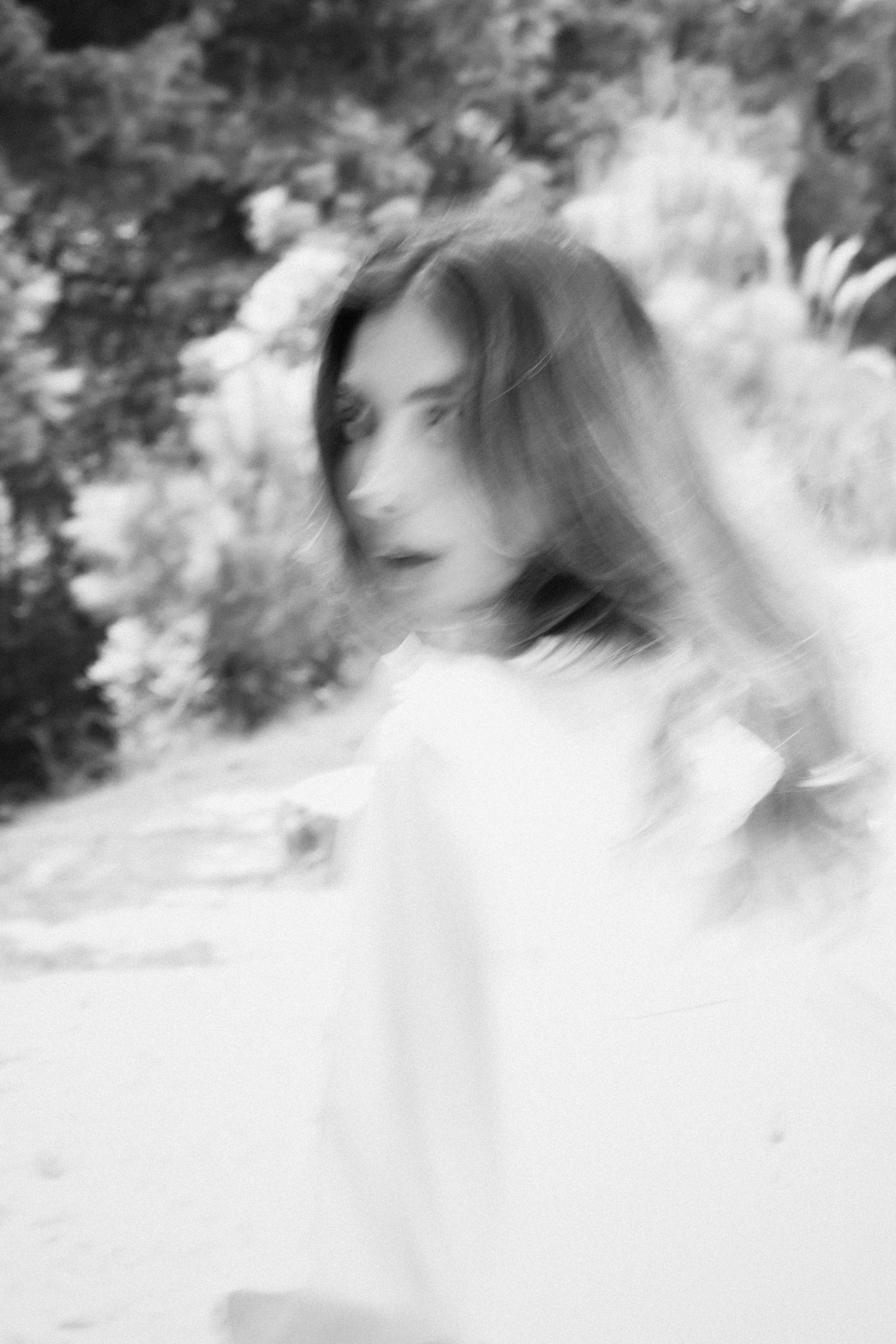Black and white portrait of a woman in motion creating a blurred effect.