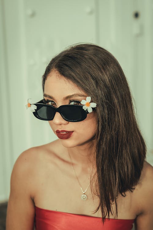 A woman in a red dress and sunglasses