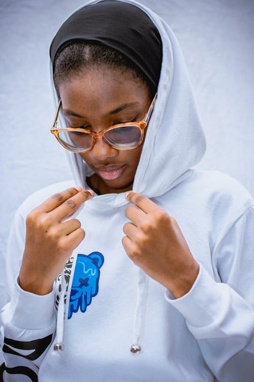 A woman in a white hoodie and glasses