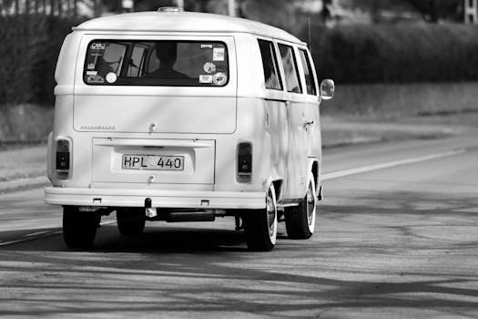 Black and white photo of a vintage Volkswagen Type 2 driving in Jönköping, Sweden.