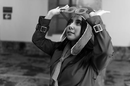 A woman in a hat and coat is holding up her head