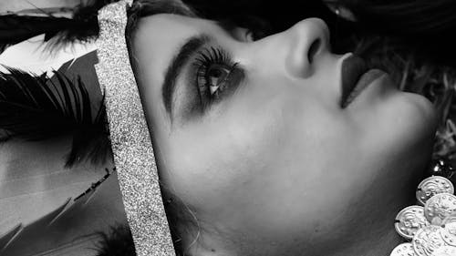 Black and white photo of woman with feathers on head