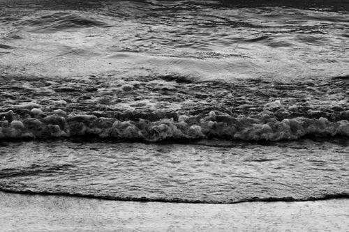 Free Monochrome image capturing ocean waves breaking on the beach. Stock Photo