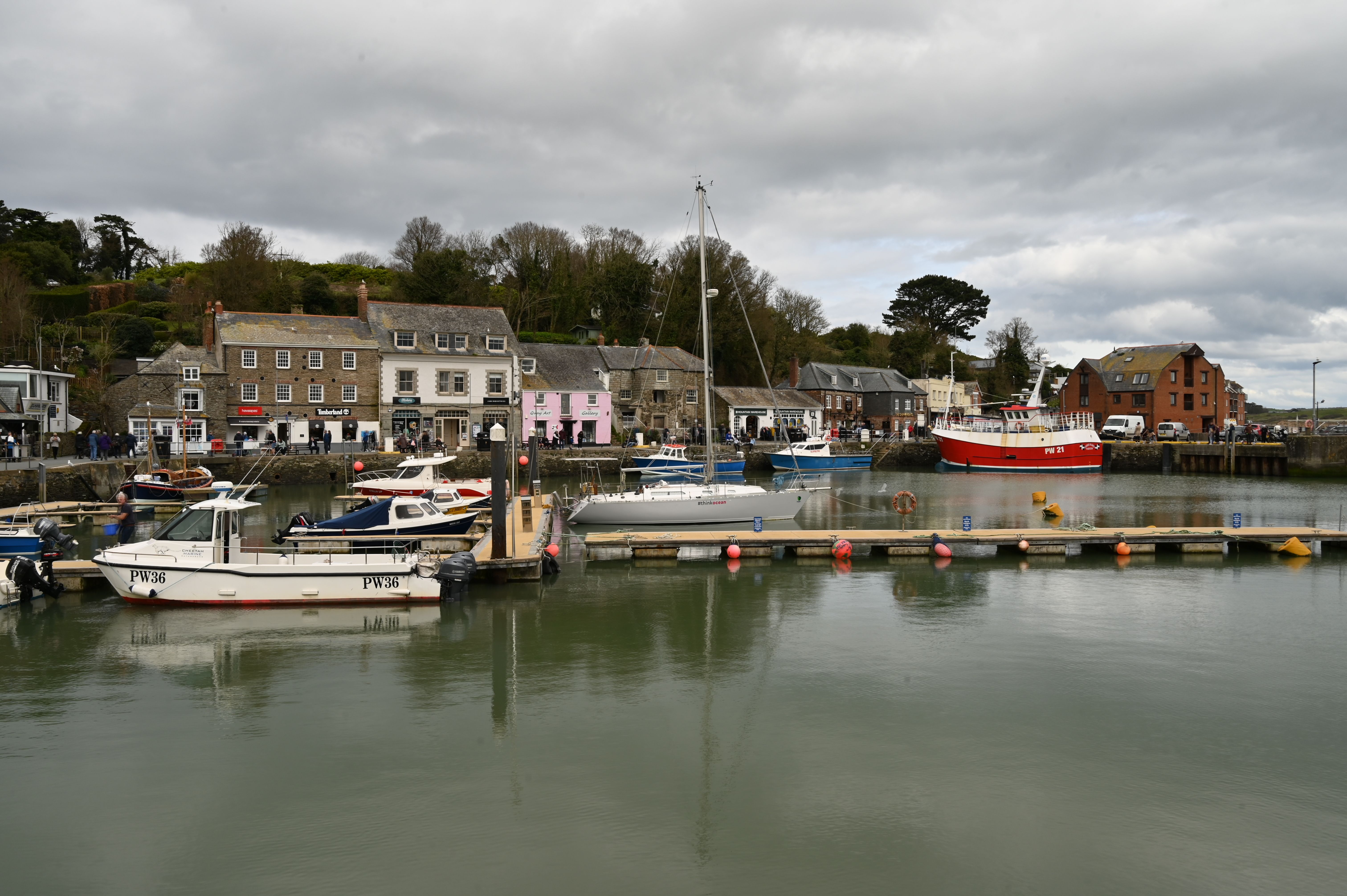 Serene view of a coastal harbor with boats docked, surrounded by charming buildings.