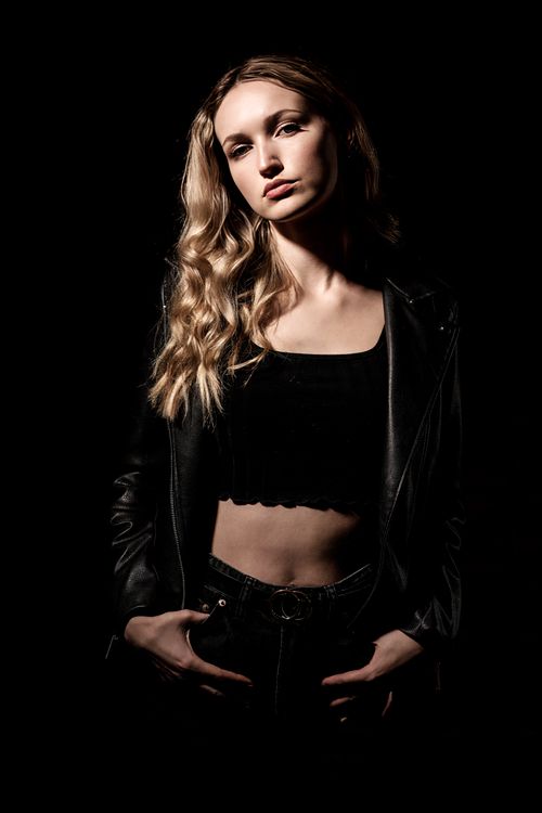 Free Portrait of a fashionable woman in a black leather jacket with dramatic lighting. Stock Photo