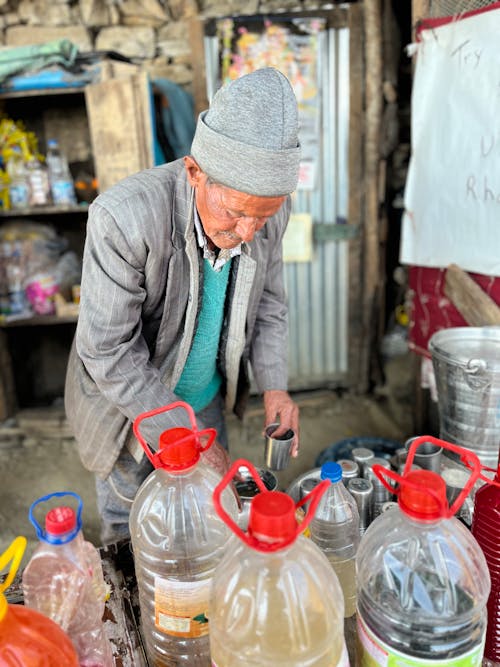 A man is standing in front of a store with bottles