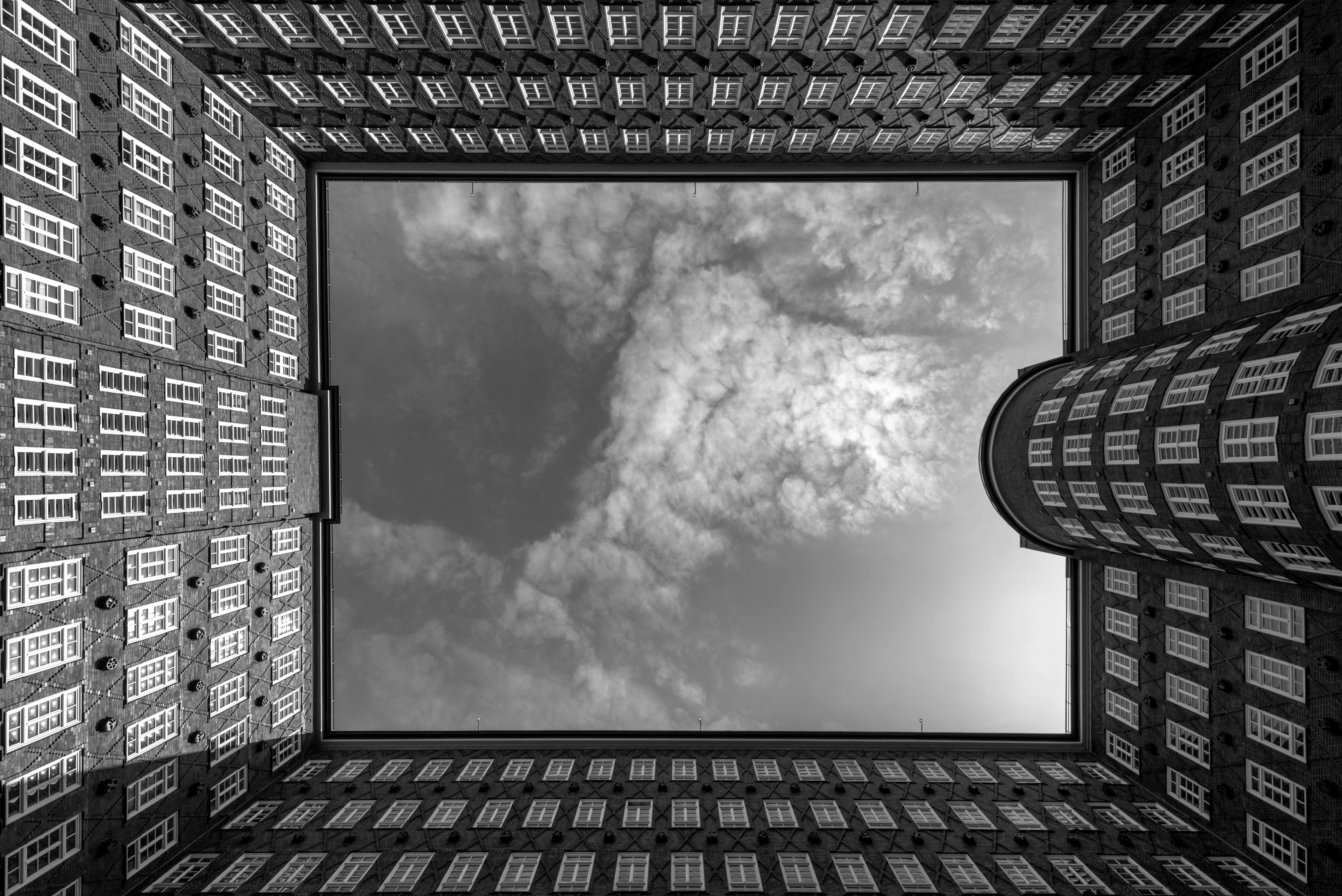 Black and white photo of the Chilehaus courtyard in Hamburg, capturing the skyward view of this iconic landmark.