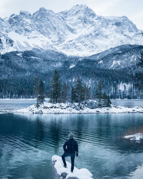 Free Hiker by the Lake Eibsee at the Foot of Mount Zugspitze in Winter Stock Photo