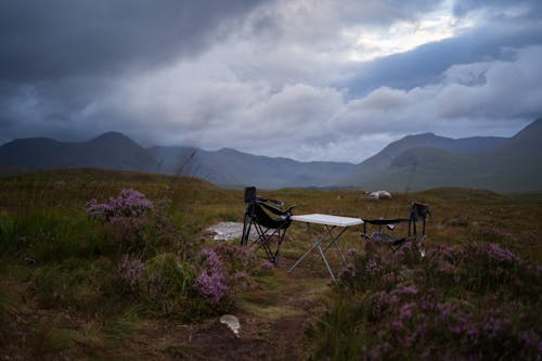 A table and chairs are set up in the middle of a field