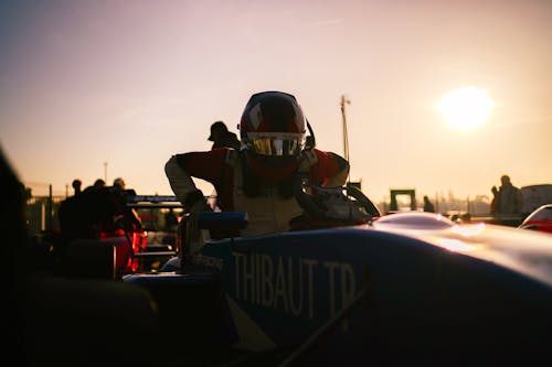 A man in a racing car at sunset