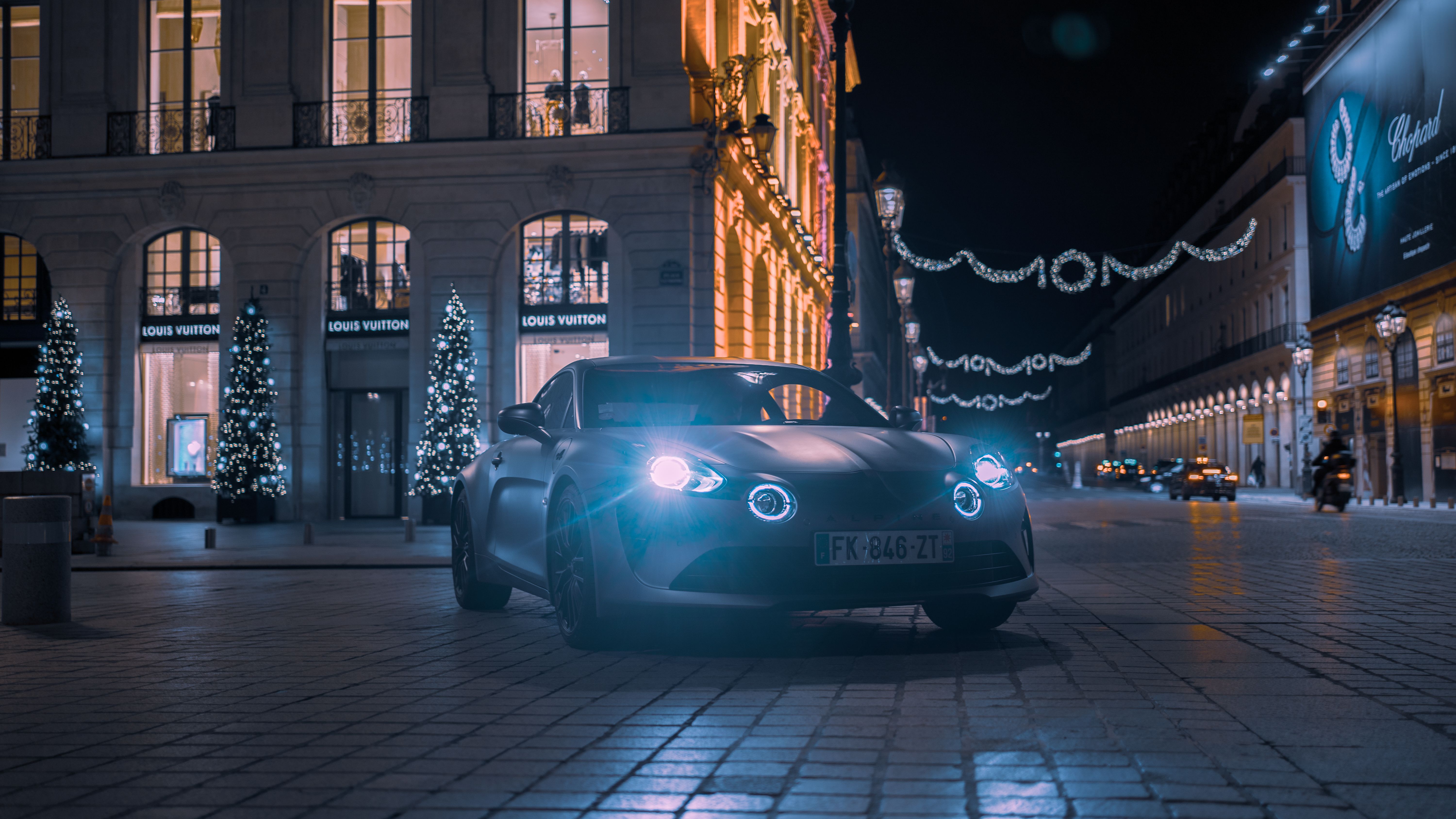 Luxury Alpine A110 showcased on illuminated city streets at night, exuding elega