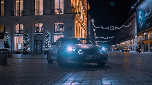 A car is parked in front of a building at night