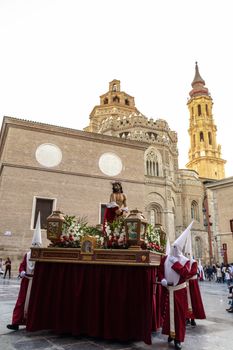 Traditional Holy Week procession in Zaragoza with capirotes and religious altar.