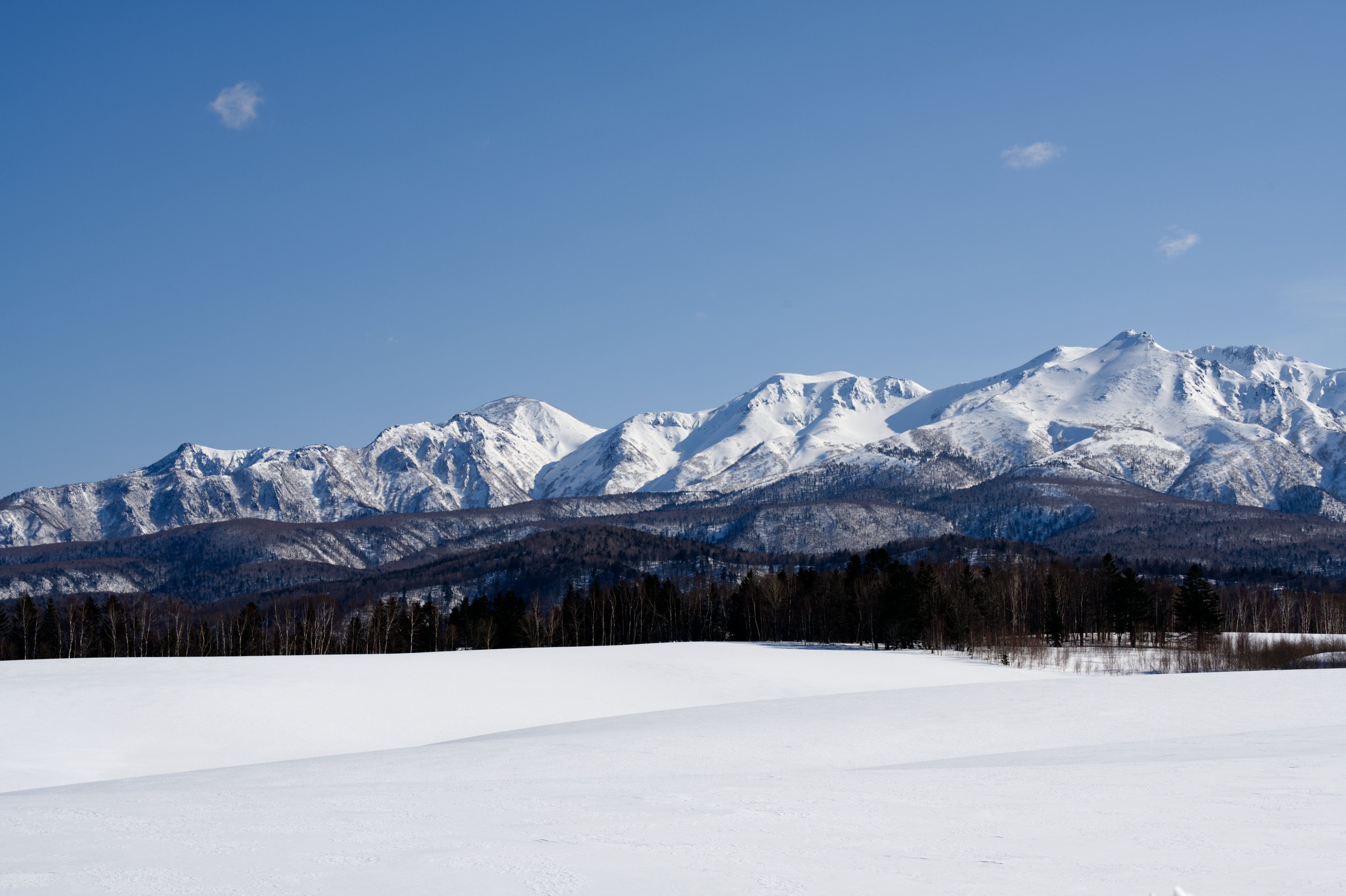 Breathtaking view of snow-capped mountains in Hokkaido, Japan during winter.