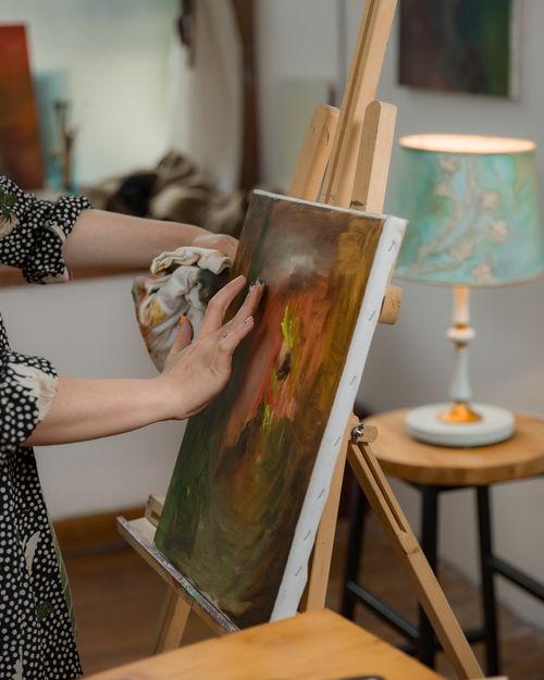Free Artist working on a colorful painting in a cozy indoor studio, showcasing creativity and handmade art. Stock Photo