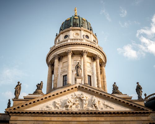 The top of a building with statues on it