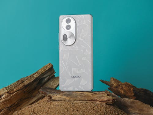 A white phone sitting on top of a log