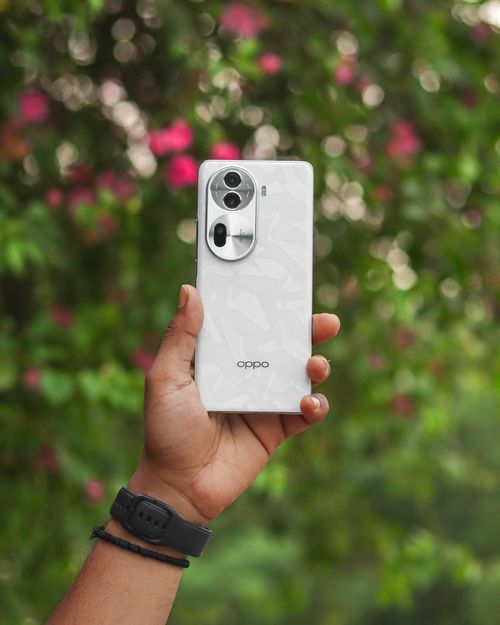 Free Close-up of a smartphone held by a hand against a blurred natural background. Stock Photo
