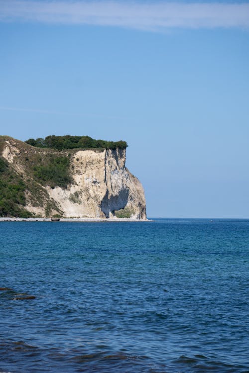 A cliff with a white rock on it near the ocean
