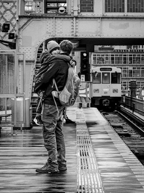 Free Black and White Photo of a Father Holding His Son while Standing on a Platform  Stock Photo