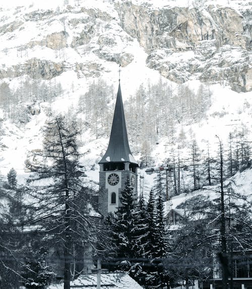 A church in the snow with a mountain in the background