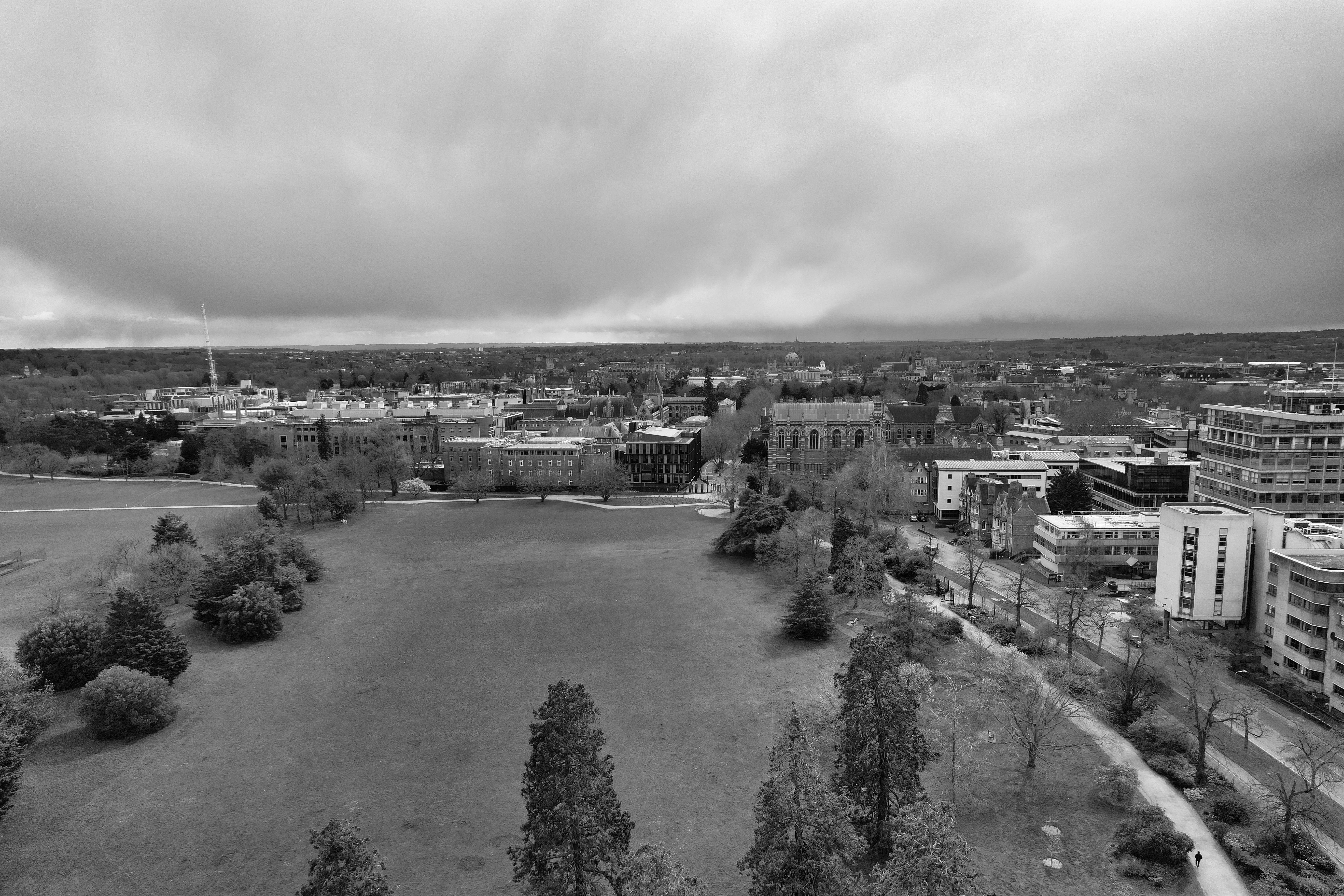 A dramatic black and white aerial view of Oxfordshire's cityscape with prominent architecture and greenery.