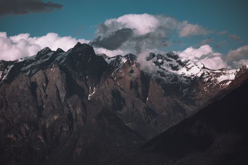 Free A dramatic view of snow-capped mountain peaks enveloped by clouds, showcasing the rugged beauty of nature. Stock Photo