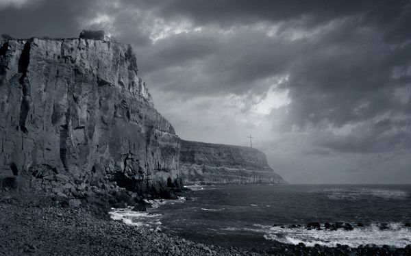 Cover art for Rise of the Empire of Ash — a rugged cliff above a stormy sea. Photo by Rene Terp on Pexels