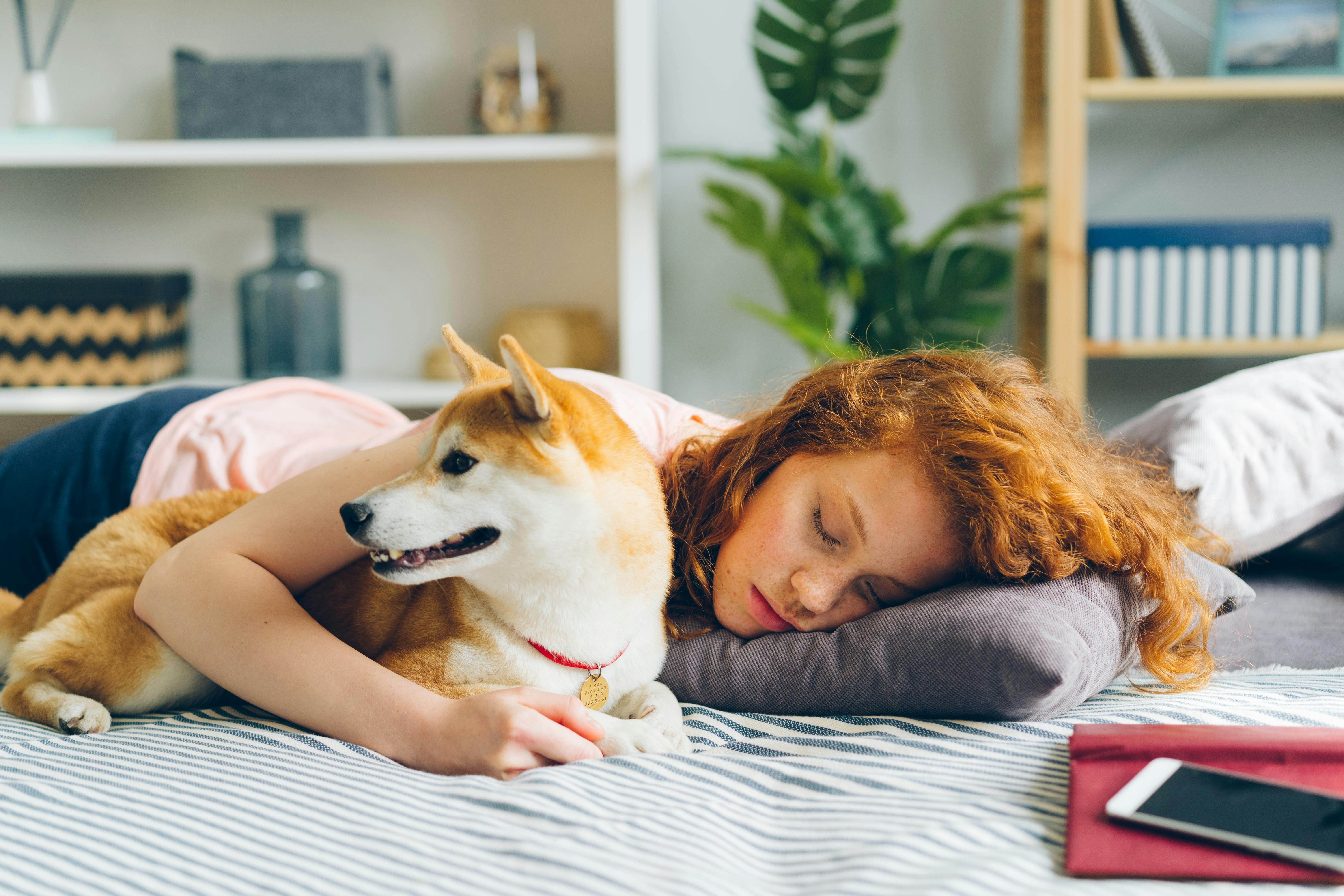Red Haired Woman Sleeping with Dog on Bed