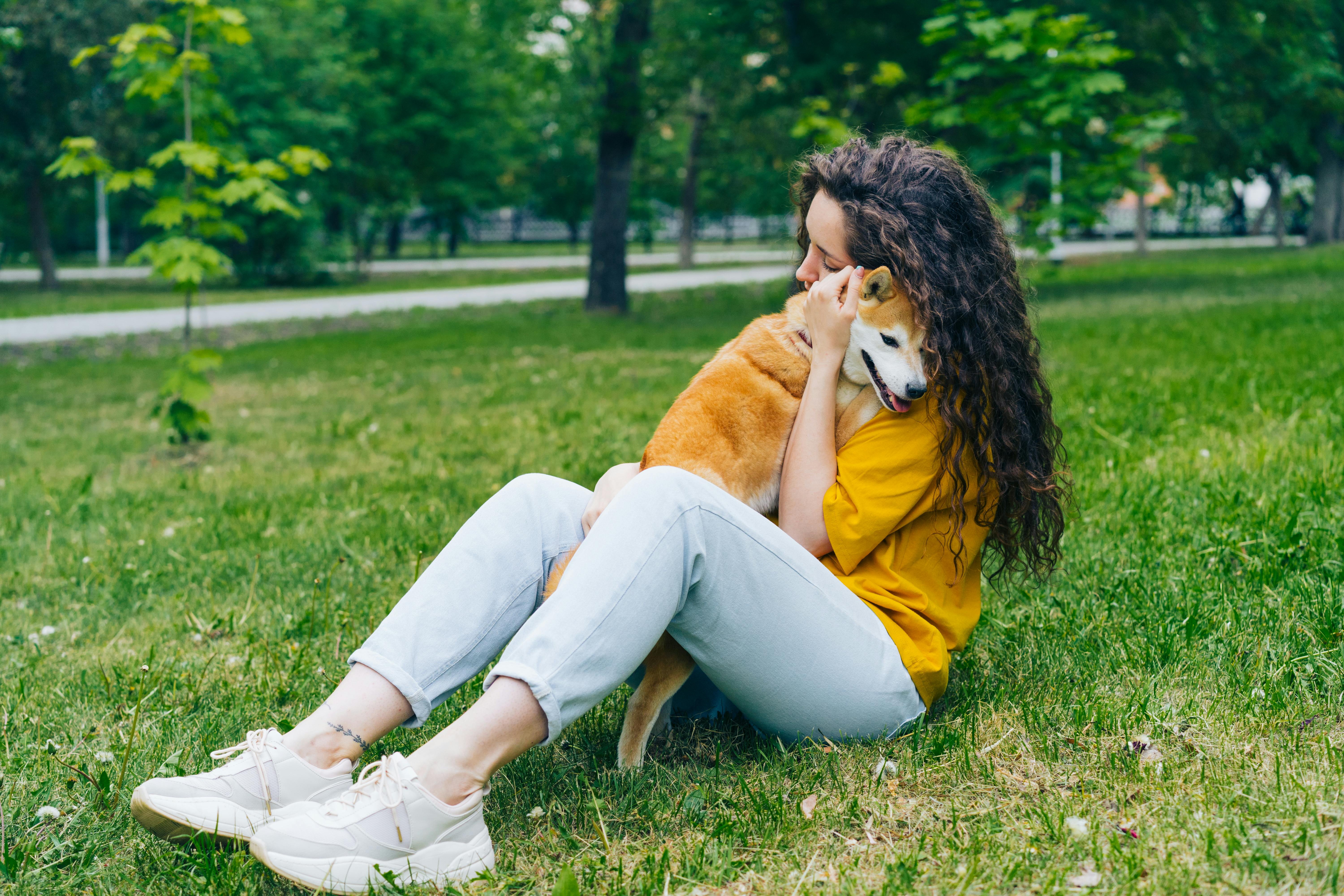 woman sitting and hugging dog