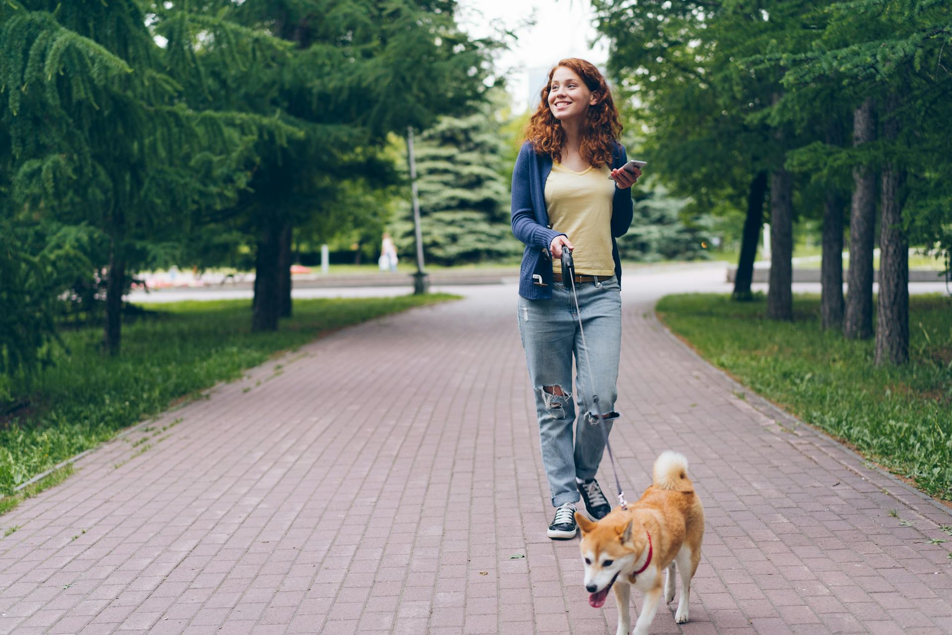 Smiling Woman Walking Dog at Park