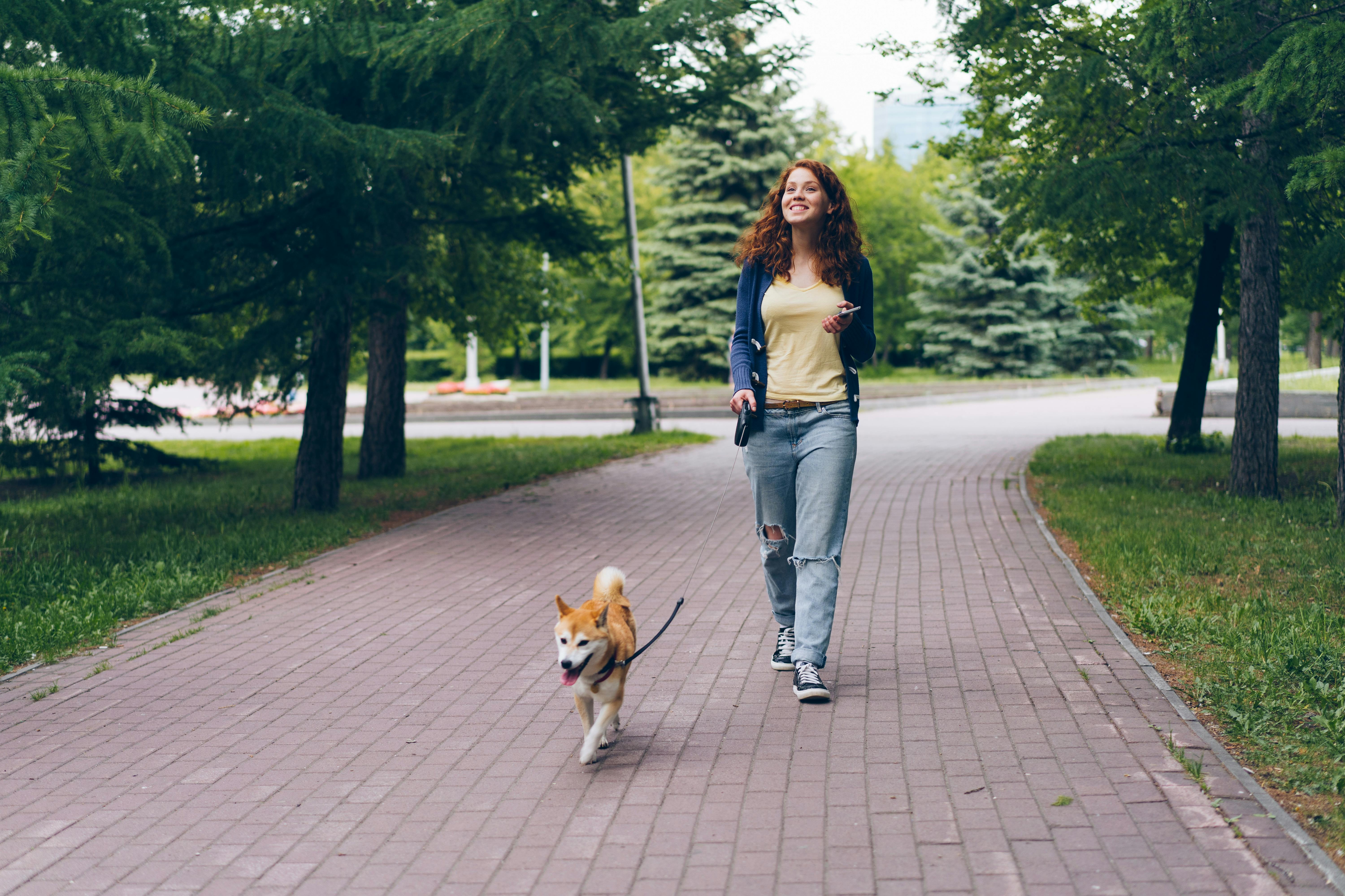 smiling woman with dog at park