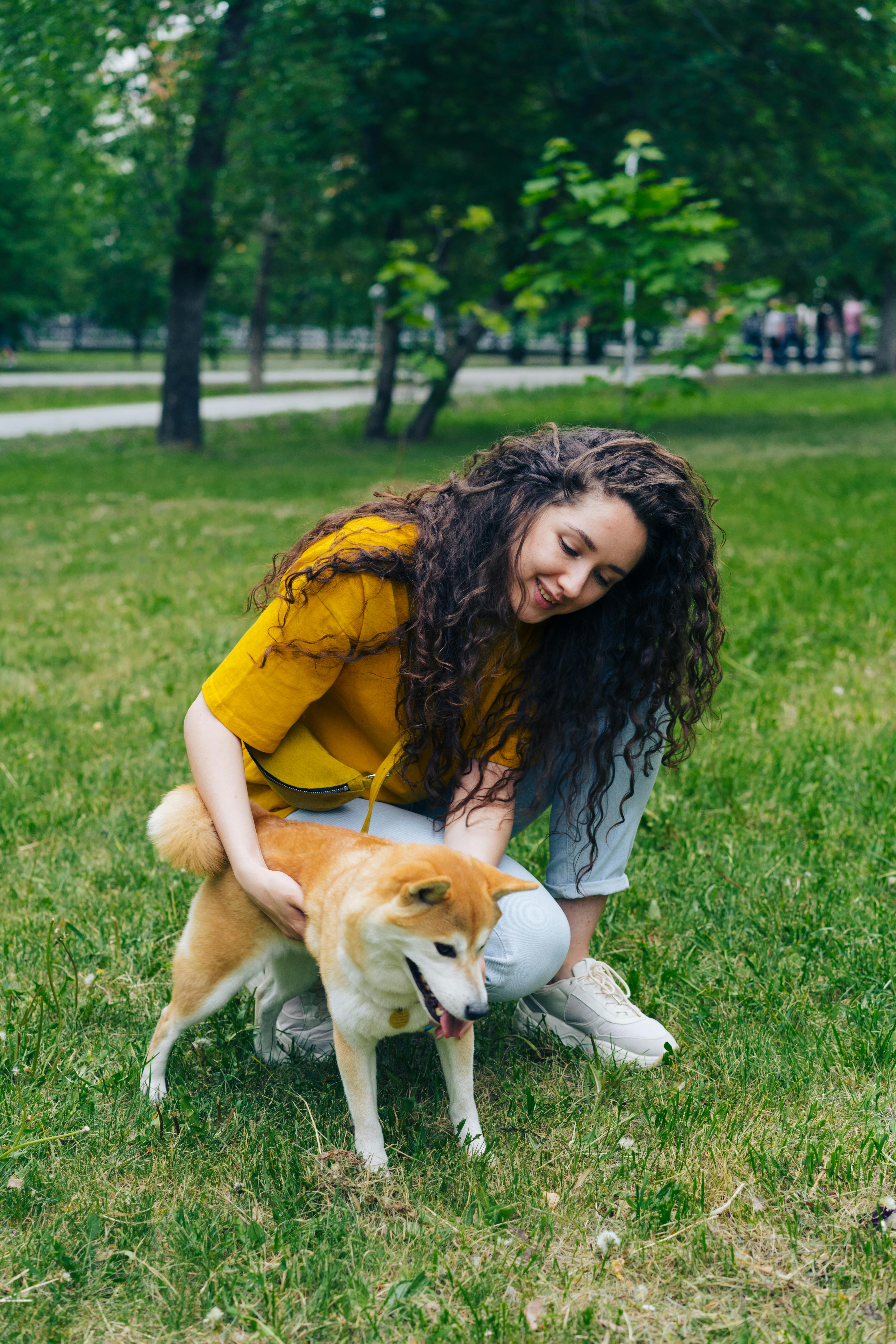 smiling woman crouching with dog