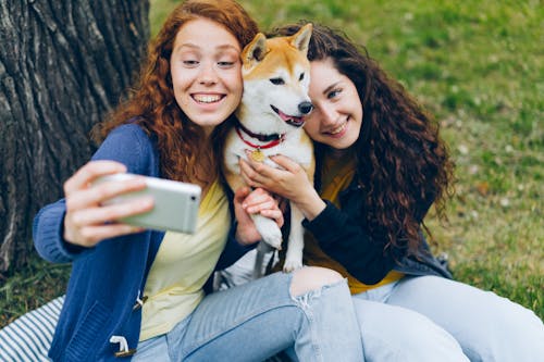 Women Sitting with Shiba Inu and Taking Selfie