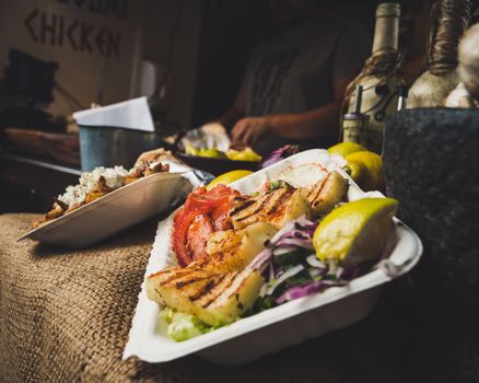 Delicious grilled chicken with fresh vegetables served at a vibrant London market.