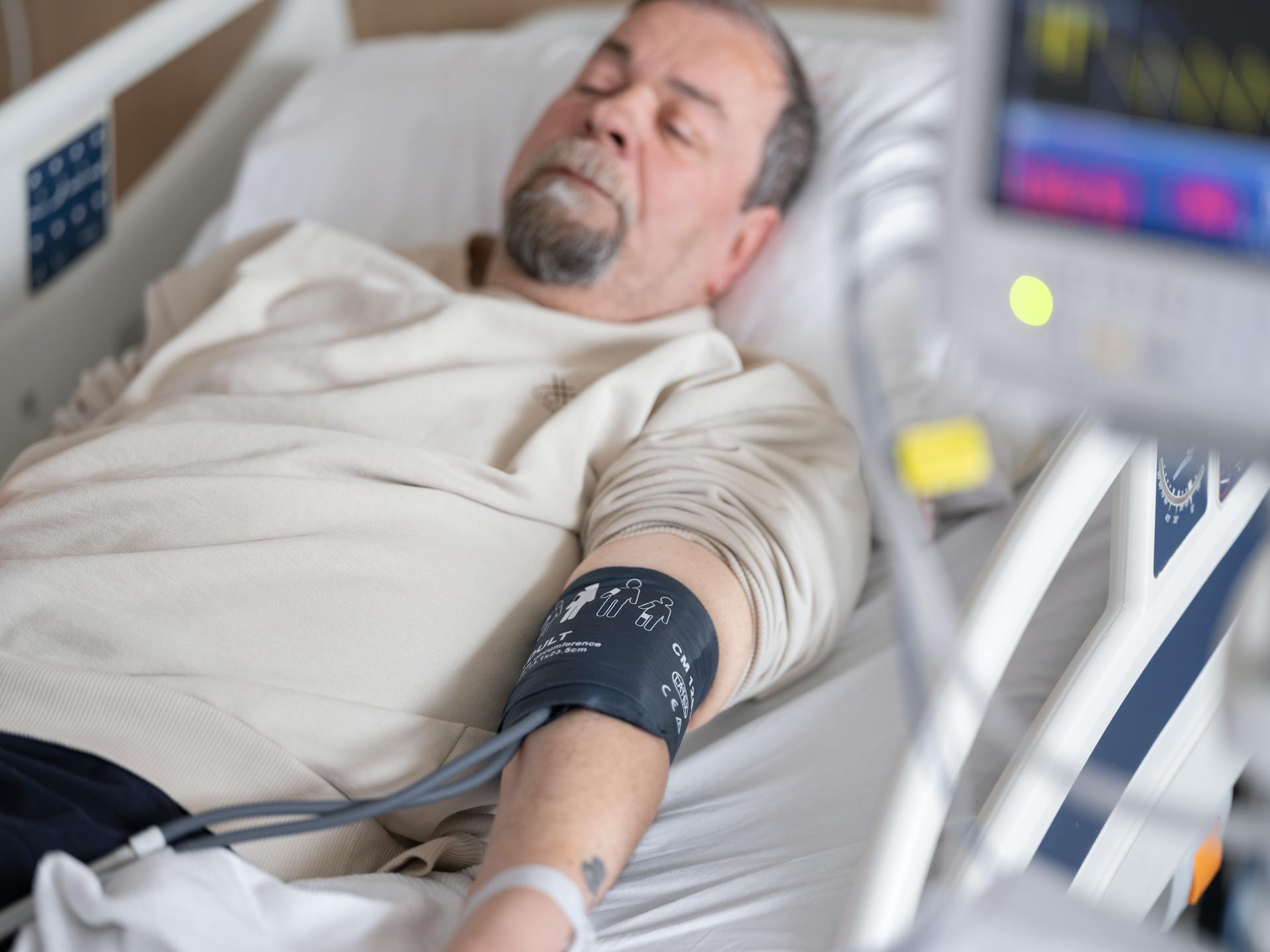 Man Laying on a Hospital Bed with a Manometer