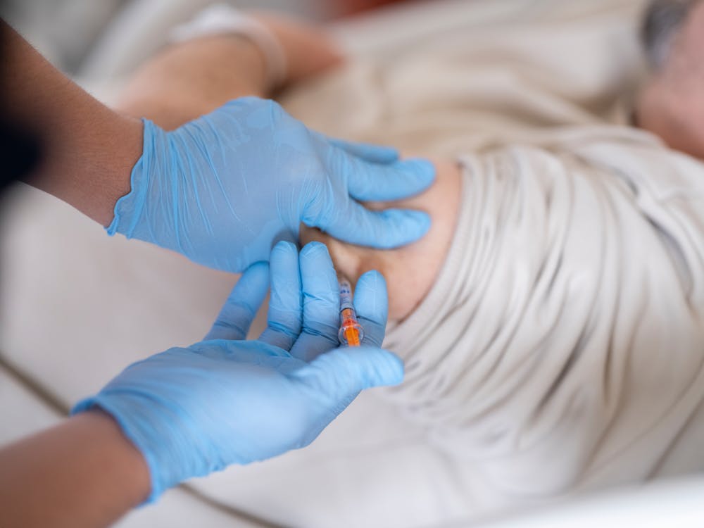 Nurse giving insulin injection to diabetic patient