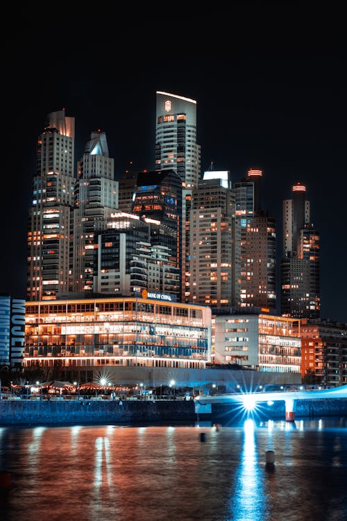 A city skyline at night with lights and water