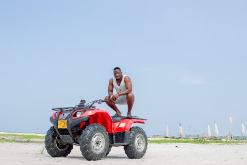 A man sitting on top of a red atv