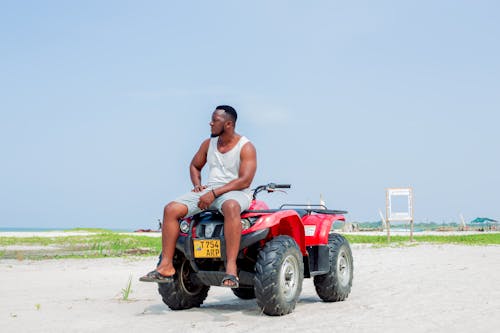A man sitting on a quad bike on the beach