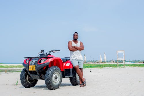 A man standing next to a four wheeler atv