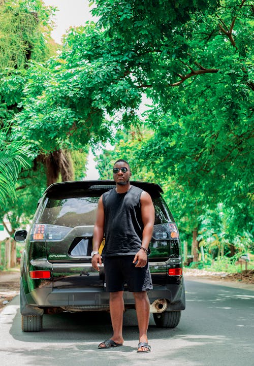 A man standing next to a black suv