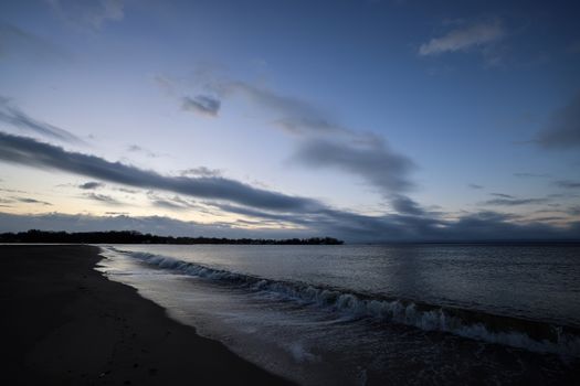 Peaceful dusk scene at Stamford Beach with gentle waves and cloudy sky.