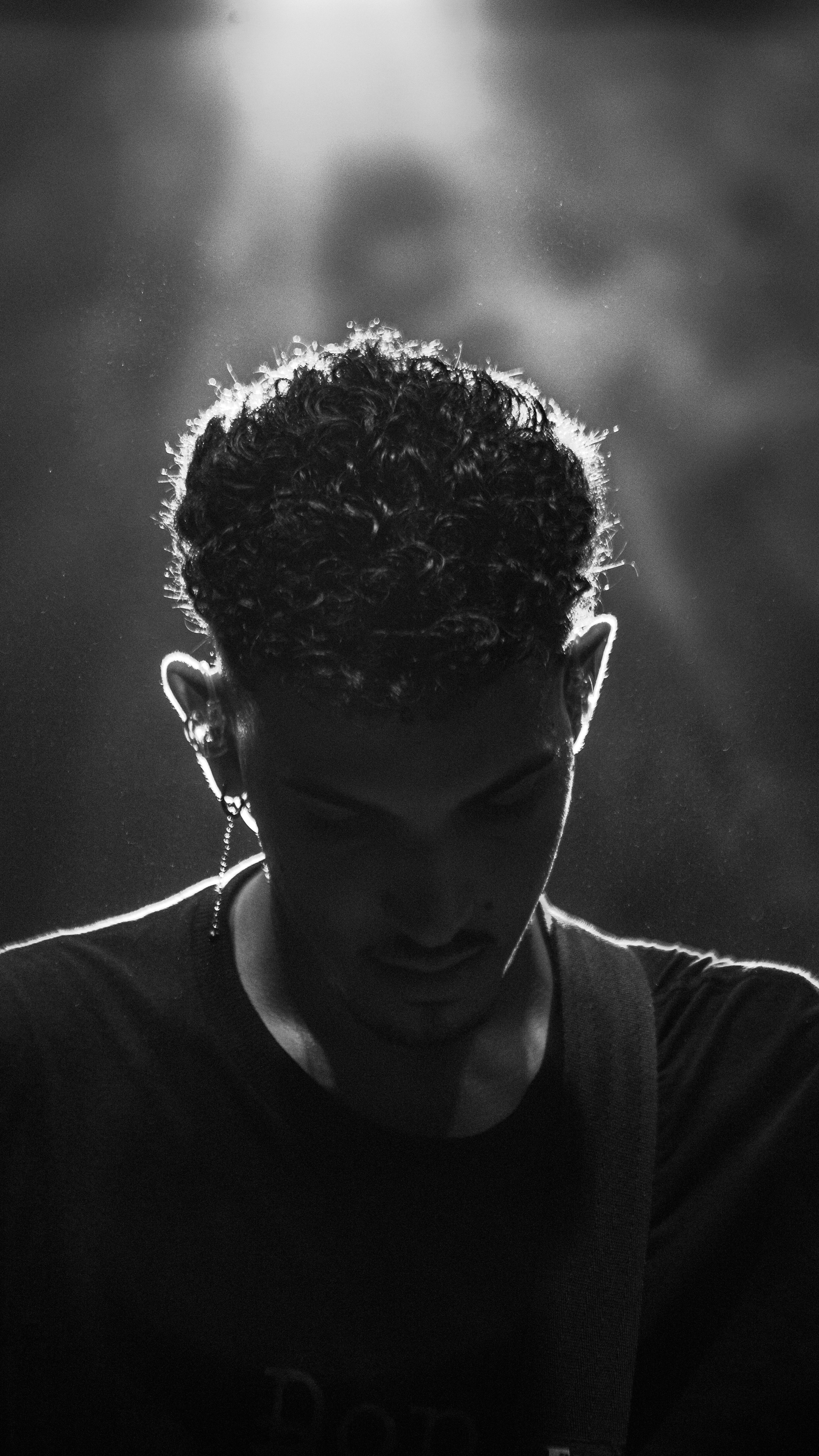Black and white portrait of a young male musician with focus on unique lighting and an expressive earring.