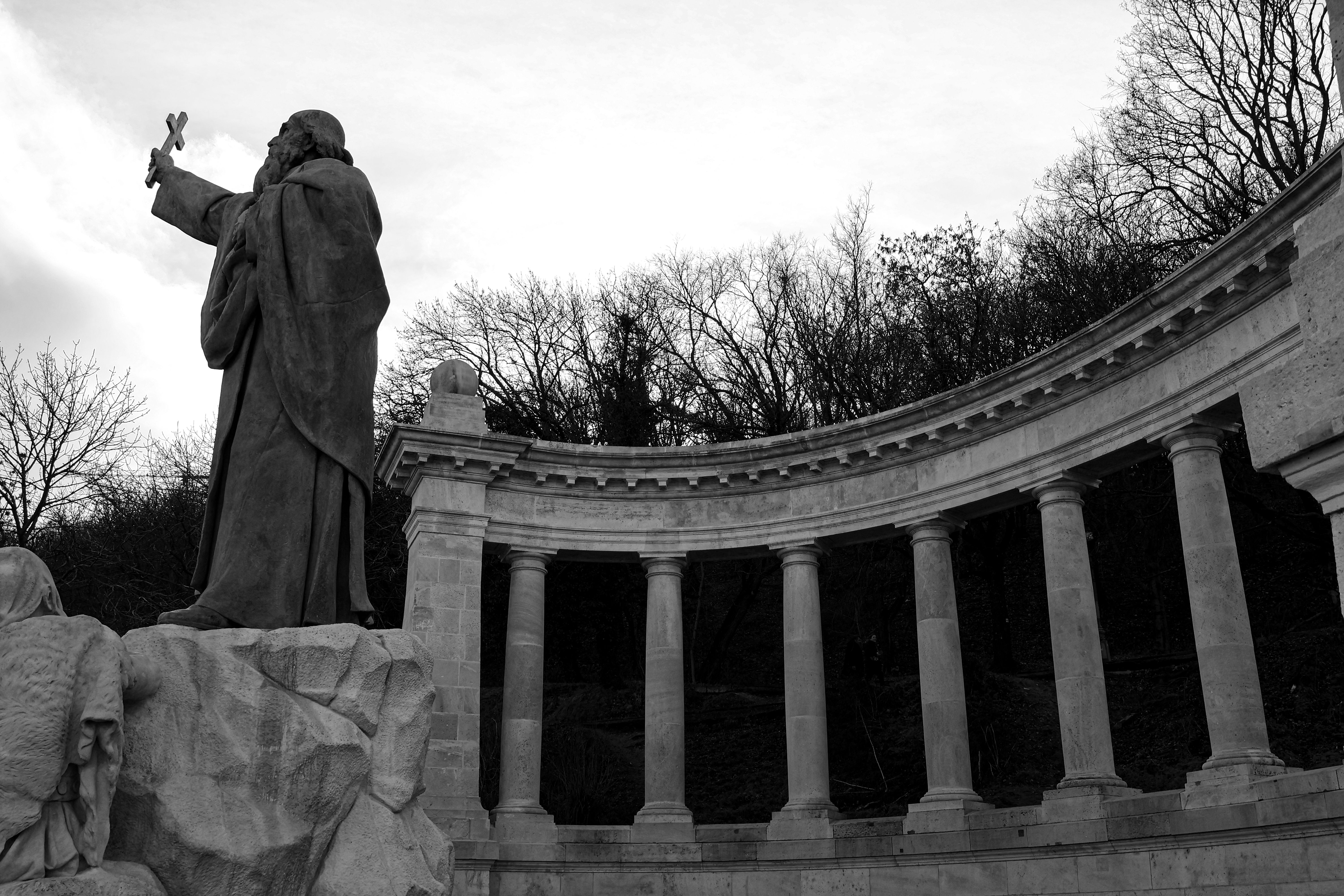 Black and white photo of a neoclassical statue and colonnade in Budapest, Hungary.