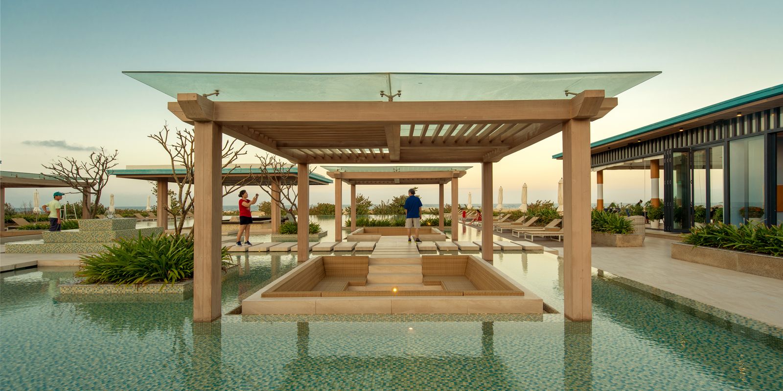 Elegant resort swimming pool at sunset with loungers