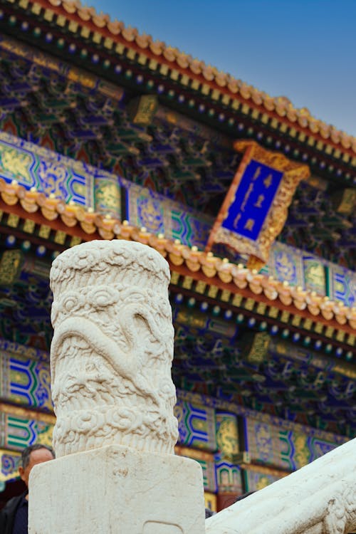 A close up of a chinese building with a statue