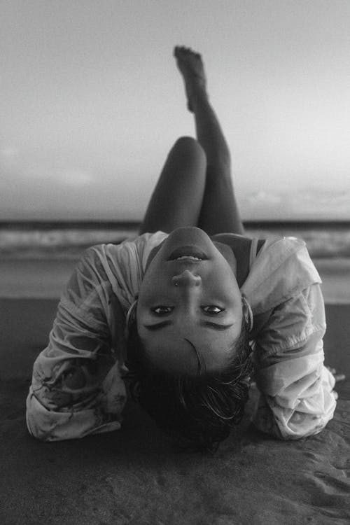 Black and white photo of a woman laying on the beach