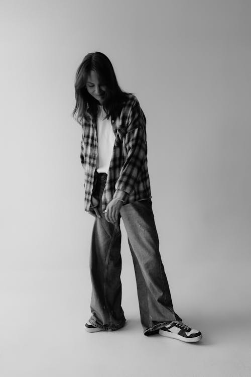 Free Model in Flannel Shirt and Jeans Standing in a Studio Stock Photo